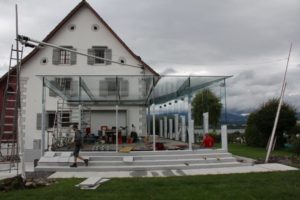 altes Bauernhaus mit moderner Glaspergola, beschattet mit Rollsegel