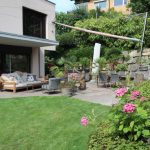 Sonnensegel befestigt an Fassade und Blocksteine